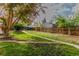 Wide backyard featuring green grass, a wooden fence, and a walkway leading to the property at 5115 Bryant St, Denver, CO 80221
