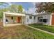 Backyard with covered patio, outdoor seating, well-maintained lawn and home's exterior at 5115 Bryant St, Denver, CO 80221