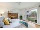 Bright bedroom with a brick fireplace and a sliding glass door leading to the backyard at 5115 Bryant St, Denver, CO 80221