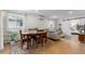 Open-concept dining and living area with wooden table and chairs, leading to a cozy bedroom at 5115 Bryant St, Denver, CO 80221