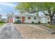 Well-kept single-story home showcasing the front yard, charming curb appeal, and orange front door at 5115 Bryant St, Denver, CO 80221