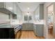 Well-lit kitchen featuring stainless steel appliances, light green cabinets, and hardwood floors at 5115 Bryant St, Denver, CO 80221