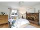 Comfortable main bedroom featuring a brick fireplace, wooden furniture, and natural lighting at 5115 Bryant St, Denver, CO 80221