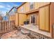 Cozy backyard featuring a wooden deck, stone patio, and vintage wooden fence at 11901 E Kepner Dr, Aurora, CO 80012