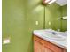 Bathroom with a single sink, wooden vanity and bright green walls at 11901 E Kepner Dr, Aurora, CO 80012