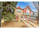 Charming townhouse featuring a stone facade, red shutters, and well-maintained landscaping at 11901 E Kepner Dr, Aurora, CO 80012