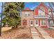 Charming townhouse featuring a stone facade, red shutters, and well-maintained landscaping at 11901 E Kepner Dr, Aurora, CO 80012