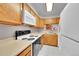 Traditional kitchen with oak cabinets, white appliances, and a window overlooking a brick wall at 11901 E Kepner Dr, Aurora, CO 80012