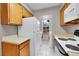 This kitchen features wood cabinets, white appliances, and a window to separate laundry machines at 11901 E Kepner Dr, Aurora, CO 80012