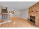 Cozy living room featuring wood floors, a brick fireplace, and staircase to the second floor at 11901 E Kepner Dr, Aurora, CO 80012