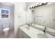 Bright bathroom with dual sinks, quartz countertop, modern lighting, and tile flooring, offering a clean design at 9486 E 107Th Ave, Commerce City, CO 80640