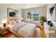 Bright, virtually staged primary bedroom featuring natural wood furniture and ample natural light from large window at 9486 E 107Th Ave, Commerce City, CO 80640