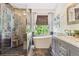 Bright bathroom with soaking tub, glass shower, gray slate tile, and marble countertop vanity with under-mount sink at 1441 Cherry Pl, Erie, CO 80516