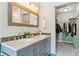 Bathroom with double vanity, marble countertop, and a closet with custom installed shelving for optimal storage at 1441 Cherry Pl, Erie, CO 80516
