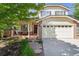 Charming two-story home with a brick facade and well-maintained landscaping in a suburban neighborhood at 1441 Cherry Pl, Erie, CO 80516