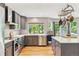 Modern kitchen featuring grey cabinets, stainless steel appliances, and a large window overlooking the backyard at 1441 Cherry Pl, Erie, CO 80516