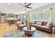Open-concept living space with kitchen view, ceiling fan, hardwood floors, and leather furnishings at 1441 Cherry Pl, Erie, CO 80516