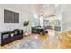 Open-concept living room featuring hardwood floors, stylish furnishings, and a view of the adjacent dining area at 1441 Cherry Pl, Erie, CO 80516