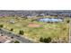 Aerial view of a neighborhood park with baseball diamond, pond, playground, walking paths, and trees at 18800 E 55Th Ave, Denver, CO 80249