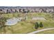 Aerial view of a neighborhood park with playground, basketball court, skate park, walking paths, and trees at 18800 E 55Th Ave, Denver, CO 80249