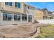Large backyard with a curved stamped concrete patio and fence, surrounded by grass and pebbles at 18800 E 55Th Ave, Denver, CO 80249