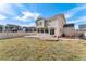 Large backyard with a concrete patio, fence, grass, and view of neighboring houses at 18800 E 55Th Ave, Denver, CO 80249