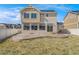 Spacious backyard with a concrete patio and fence, surrounded by grass, and neighboring houses at 18800 E 55Th Ave, Denver, CO 80249