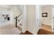 Bright foyer with staircase, carpet flooring, and an adjacent half bathroom adds functionality to the home's layout at 18800 E 55Th Ave, Denver, CO 80249