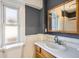 Classic bathroom features a wood vanity, a matching mirror, and natural light from the adjacent window at 339 Delaware St, Denver, CO 80223