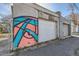 A detached garage with colorful abstract graffiti art on the wall at 339 Delaware St, Denver, CO 80223
