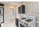 Quaint kitchen offers black and white accents with ample sunlight from a window above the range at 339 Delaware St, Denver, CO 80223
