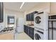 Efficient kitchen featuring modern appliances, dark cabinets, and a laundry setup for convenience at 339 Delaware St, Denver, CO 80223