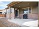 Covered back patio features brick accents, sliding door, and concrete floor for outdoor enjoyment at 25403 E 2Nd Ave, Aurora, CO 80018