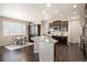 Open kitchen with island, stainless steel appliances, modern fixtures, and adjacent dining area at 25403 E 2Nd Ave, Aurora, CO 80018