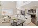 Bright and airy living room seamlessly connected to a modern kitchen with dark cabinetry at 25403 E 2Nd Ave, Aurora, CO 80018