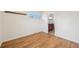 Bedroom with wood floors leads to bathroom; featuring neutral walls and a bright window at 3293 S Florence Ct, Denver, CO 80231