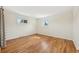 Sunlit bedroom features hardwood floors, two windows, and neutral paint at 3293 S Florence Ct, Denver, CO 80231