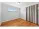 Cozy bedroom features hardwood floors, neutral paint, and natural light from the window at 3293 S Florence Ct, Denver, CO 80231