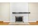 Close up of a white brick fireplace with a black mantel at 3293 S Florence Ct, Denver, CO 80231