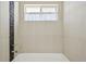 Close-up of the shower showcasing light-colored tiles with black stone pebble accents at 3293 S Florence Ct, Denver, CO 80231