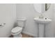 Elegant bathroom featuring a pedestal sink, modern toilet, and decorative mirror at 19120 E 96Th Pl, Commerce City, CO 80022