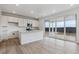 Open concept kitchen with white cabinets, stainless steel appliances, large island, and sliding glass doors at 19120 E 96Th Pl, Commerce City, CO 80022