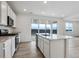 Bright kitchen with white cabinets, stainless steel appliances, and a center island with quartz countertops at 19120 E 96Th Pl, Commerce City, CO 80022