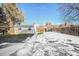 Large backyard featuring a detached building, grassy areas and snow covered patches at 2380 Jasmine St, Denver, CO 80207