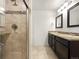 Well-lit bathroom with tiled shower, double vanity, and granite countertops at 6108 Kochia Ct # 104, Erie, CO 80516