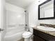 Bright bathroom features a bathtub and shower combination with a tiled floor and granite counters at 6108 Kochia Ct # 104, Erie, CO 80516