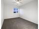 Clean, empty bedroom with neutral carpet, bright window, and modern ceiling fan at 6108 Kochia Ct # 104, Erie, CO 80516