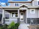 Charming home featuring a welcoming front porch with stone accents and beautiful landscaping at 6108 Kochia Ct # 104, Erie, CO 80516