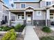 Welcoming home featuring a covered front porch with stone pillars and a beautifully landscaped garden at 6108 Kochia Ct # 104, Erie, CO 80516