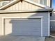 Attached gray garage with concrete driveway and the address number '104' at 6108 Kochia Ct # 104, Erie, CO 80516